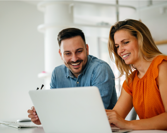 Smiling man and woman looking at laptop