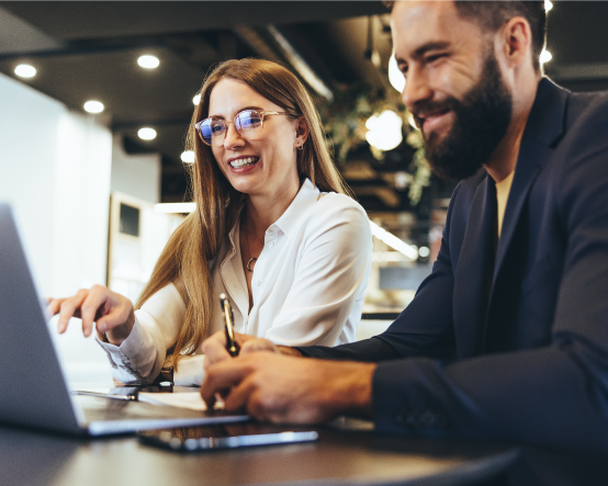 Woman and man smiling looking at laptop 