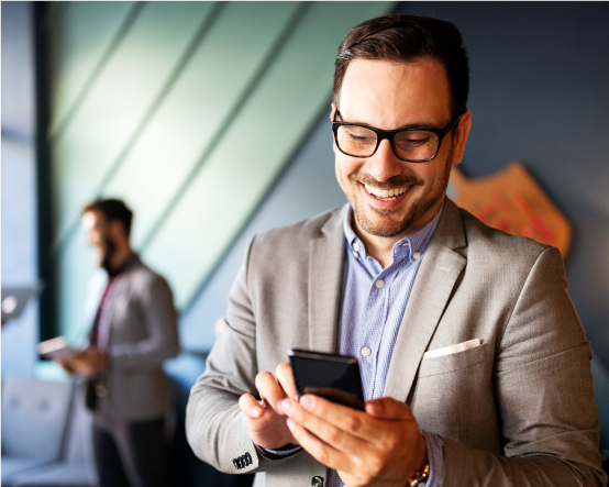 Man wearing a suit and glasses smiling at phone
